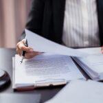 Person reviewing legal documents at a desk with a gavel